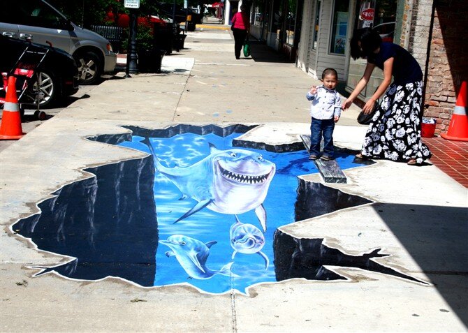 3D sidewalk floor art of a shark breaking through pavement